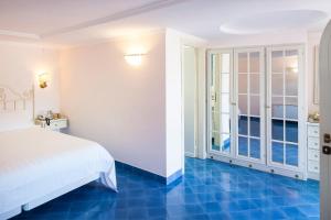 a bedroom with a white bed and blue floors at Hotel Continental Ischia in Ischia