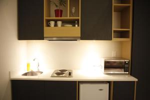 a kitchen with a sink and a microwave at The Grace Hotel in Bogotá