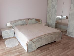 a bedroom with a bed and a mirror on the wall at Vila Laima in Šventoji
