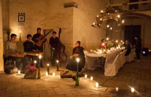 a group of people sitting around a table with candles at Hacienda Santa Barbara Casa Malinche in Huamantla