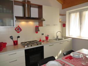 eine Küche mit einem Herd Top-Backofen neben einer Spüle in der Unterkunft Bella Villa Apartments in Riva del Garda