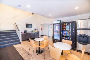 a cafeteria with two tables and a soda machine at Motel 6-Rigby, ID in Lorenzo