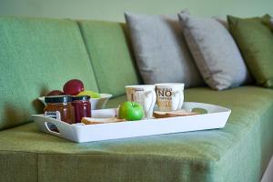 a tray of food on a couch with drinks and snacks at Nanakis Beach Apartments in Stavros