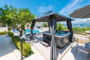 - un bain à remous avec un parasol sur la terrasse dans l'établissement Villa Markoc, à Cavtat
