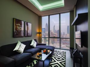 a living room with a couch and a large window at Saray Prime Suites in Kuwait