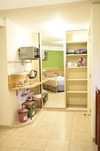 a room with a kitchen and a bedroom with a bed at AVEMAR Apart Hotel in Posadas