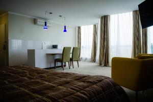 パラマリボにあるGess Hotelのベッドとテーブルと椅子のあるホテルの部屋