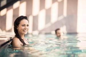 a woman swimming in a swimming pool at Hotel Lamm in Castelrotto