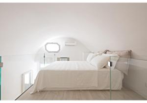 ein weißes Schlafzimmer mit einem Bett und einem Fenster in der Unterkunft La Rosa del Corso in Fasano