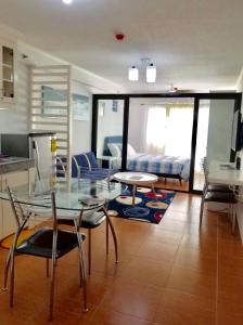 a living room with a glass table and chairs at Fully Furnished 1BR Condo Unit in Cagayan de Oro