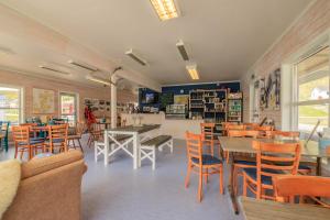 ein Esszimmer mit Tischen und Stühlen sowie eine Bibliothek in der Unterkunft Seaside cabin Skarsvåg in Skarsvåg