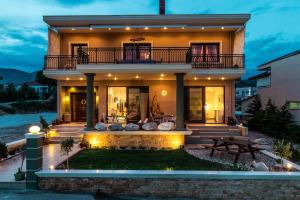 a house with a balcony and a patio at Vintage Suites in Limenaria