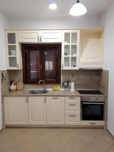 a kitchen with white cabinets and a sink at Apartman Popovic Cetinje in Cetinje
