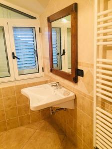 ein Bad mit einem Waschbecken und einem Spiegel in der Unterkunft Agriturismo "LE ANFORE" in Ariano Irpino