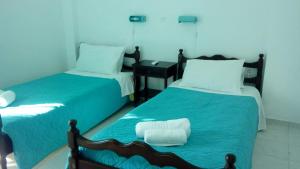 a bedroom with two beds with blue sheets at Yellow house in Lassi