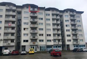 un grande condominio con auto parcheggiate in un parcheggio di Apartment Nesrine a Bihać