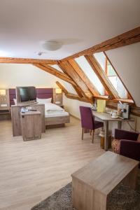 a bedroom with a bed and a desk and a tv at Bodensee Hotel Sternen in Uhldingen-Mühlhofen