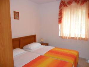 two beds in a bedroom with a rainbow blanket at Apartments Villa Bayview in Trogir +33 photos