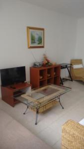 a living room with a glass table and a tv at Apartments Villa Bayview in Trogir