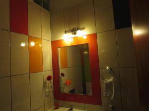 Apartamento bonito في بورديرا: حمام به مرآة وأزهار على الحائط