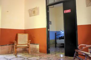a room with a door and a chair and a bed at Hostal La Ermita in Mérida