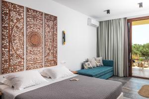 a bedroom with a bed and a blue couch at Vintage Suites in Limenaria