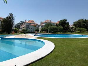 a large swimming pool in a park with buildings in the background at La Toja. Urb. Rueiros. in Isla de la Toja