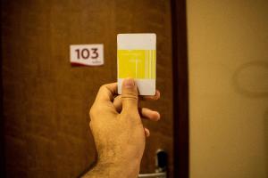 a person holding up a cell phone in front of a door at Rainha Hotel in Goiana