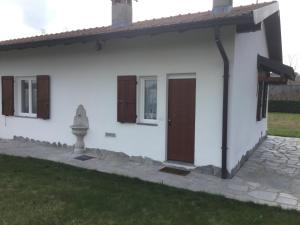 Casa blanca con puerta y ventanas marrones en La Casetta, en Pombia
