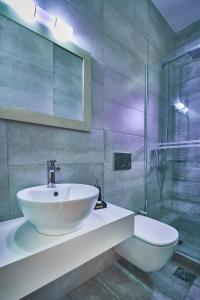 a bathroom with a sink and a glass shower at Nanakis Beach Luxury Apartments in Stavros