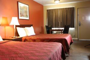 una camera d'albergo con due letti e un tavolo di Americas Best Value Inn Kelso a Kelso