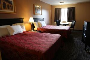 una camera d'albergo con due letti e un tavolo con sedie di Americas Best Value Inn Kelso a Kelso