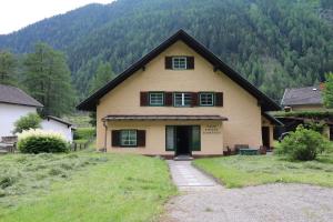 dom na wzgórzu z górami w tle w obiekcie Ferienhaus Rieger w mieście Mallnitz