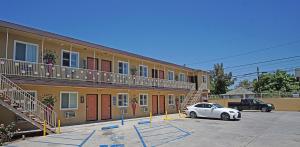 a white car parked in front of a building at Rosa Bell Motel - Los Angeles in Los Angeles