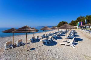 a group of chairs and umbrellas on a beach at Apartment Klara in Krk