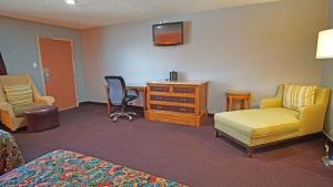 a hotel room with a bed and a desk and chairs at Los Angeles Inn & Suites - LAX in Los Angeles