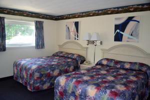 una camera d'albergo con due letti e una finestra di Stratford Suburban Motel a Stratford