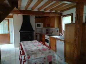 a kitchen with a table and a stove top oven at Le Clos des Hortensias in Toutainville