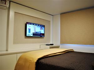 グラマドにあるApartamento Moderno Centro Gramadoのベッドルーム1室(ベッド1台、壁掛け薄型テレビ付)