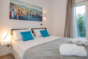 a bedroom with a large white bed with blue pillows at Luxury apartment Shelena in Mravince +43 photos