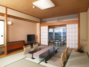 
a living room filled with furniture and a tv at Hotel New Century in Fujikawaguchiko

