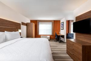 a hotel room with a bed and a flat screen tv at Holiday Inn Express Chapel Hill by IHG in Chapel Hill