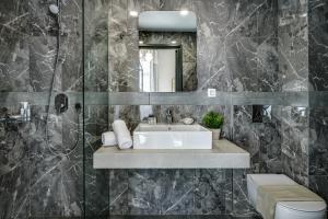 a bathroom with a sink and a mirror at Mosaic in Chania Town