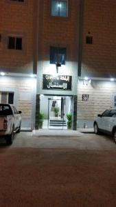 dos autos estacionados en un estacionamiento frente a un edificio en Almalki furnished units, en Al Thybiyah