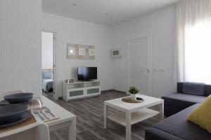 sala de estar con sofá y TV en Home Family en Tossa de Mar