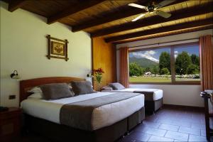 ein Schlafzimmer mit zwei Betten und einem großen Fenster in der Unterkunft Hotel Pucon Green Park in Pucón