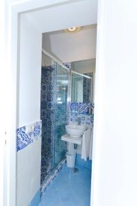 a bathroom with blue and white tiles and a sink at La Perla Blu in Capri
