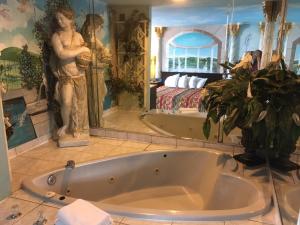 a bath tub in a bathroom with a bedroom at Deluxe Inn in Galloway