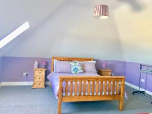 a bedroom with a wooden bed with purple walls at Meadow View in Trim