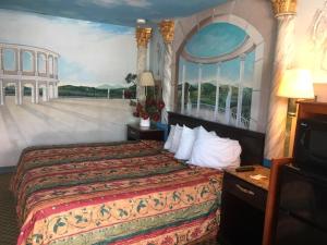 una habitación de hotel con una cama y un cuadro en la pared en Deluxe Inn, en Galloway